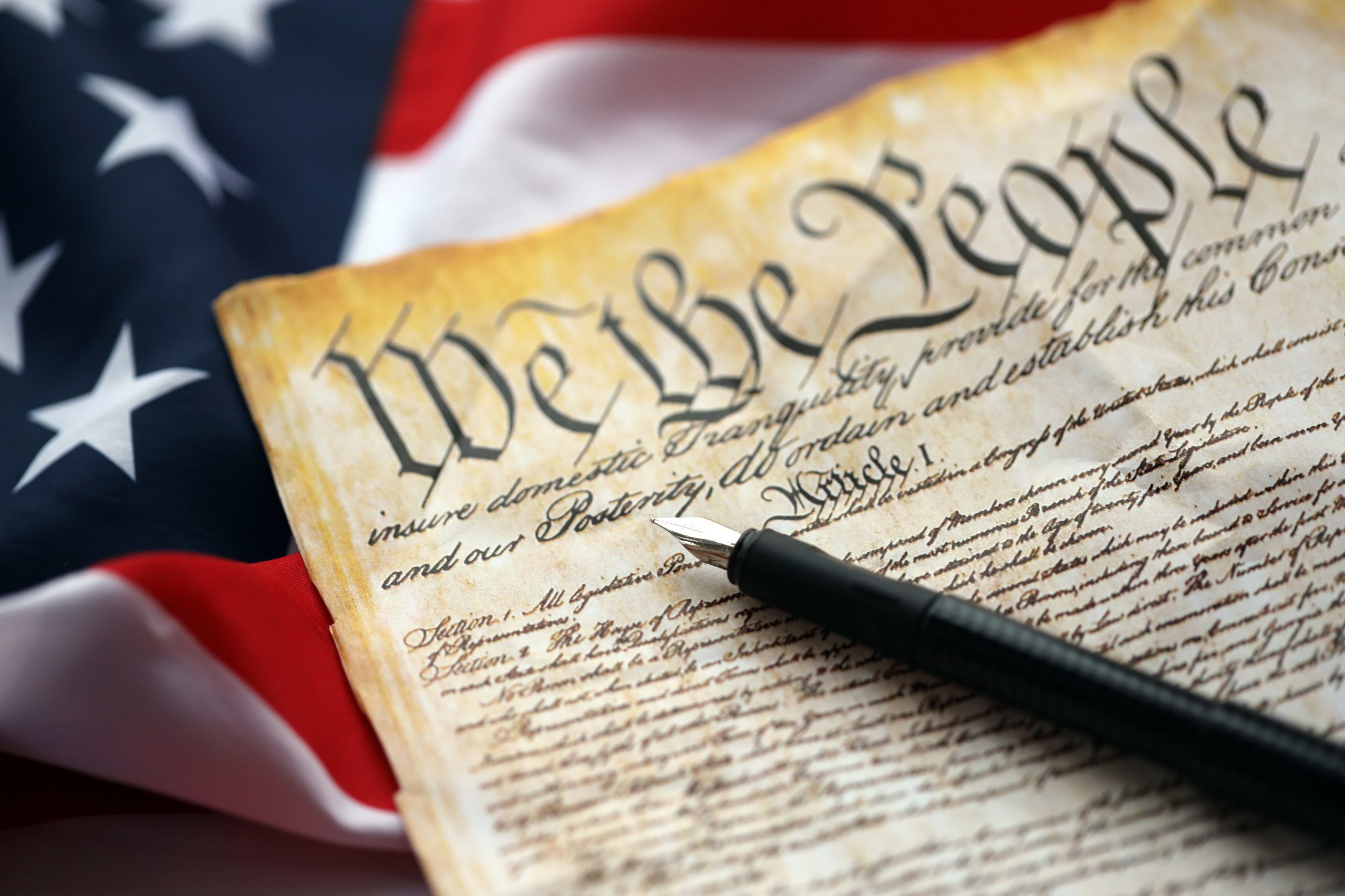 Preamble to the Constitution of the United States and American Flag close up